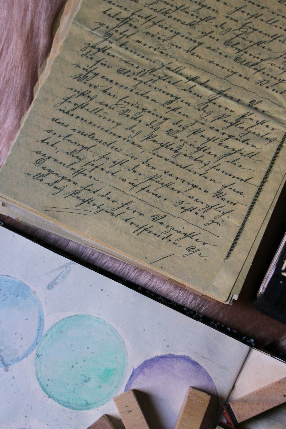 Handwritten manuscript pages with an ink pen and reading glasses